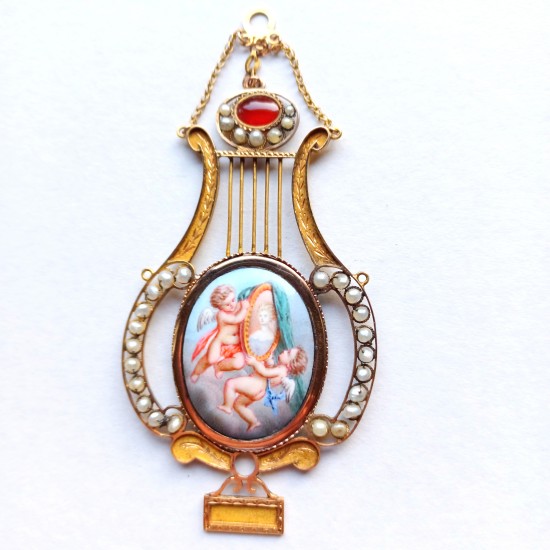 Goldener Anhänger mit Perlen in Form einer Lyra. Mittig ein Medaillon mit Putti.