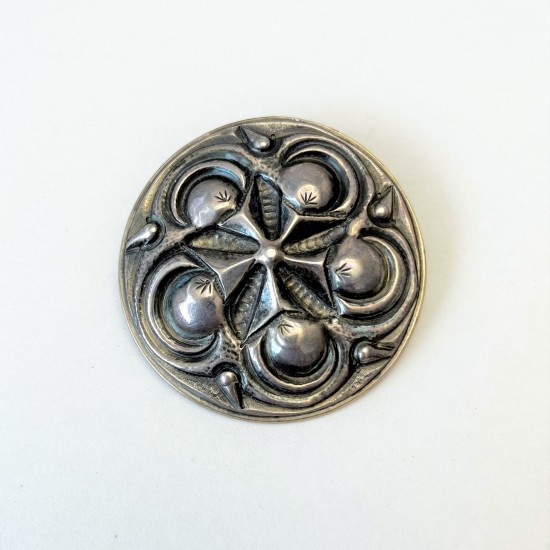 Runde Brosche aus Metall.