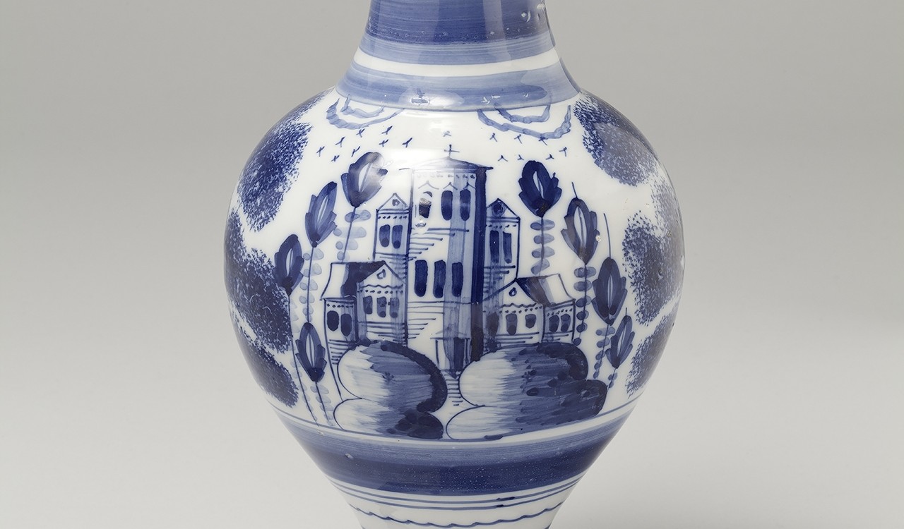 Krug mit weiß-blauer Bemalung einer Architektur in Landschaft