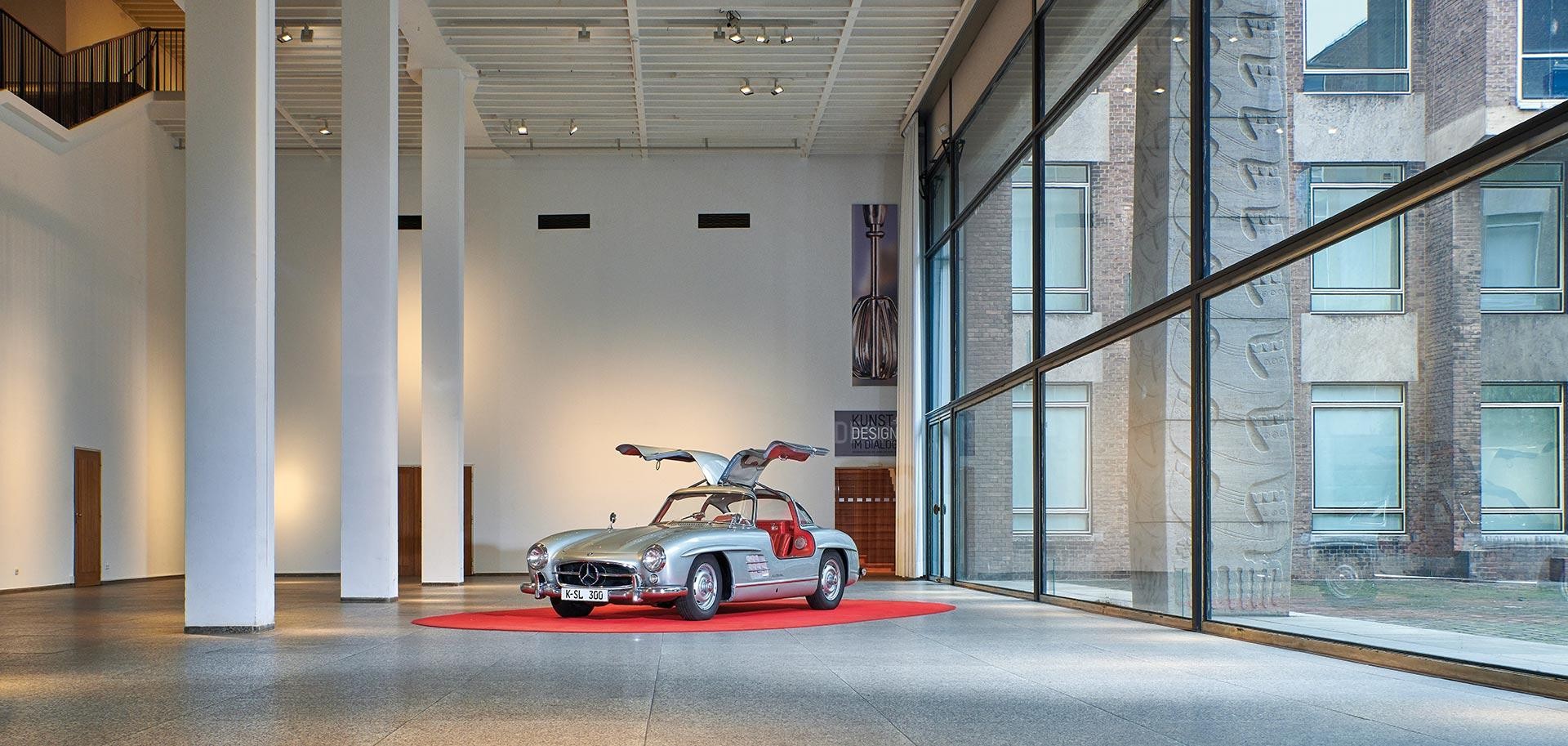 Große Halle mit Mercedes Gullwing 300 SL und Eingang in die Designausstellung.