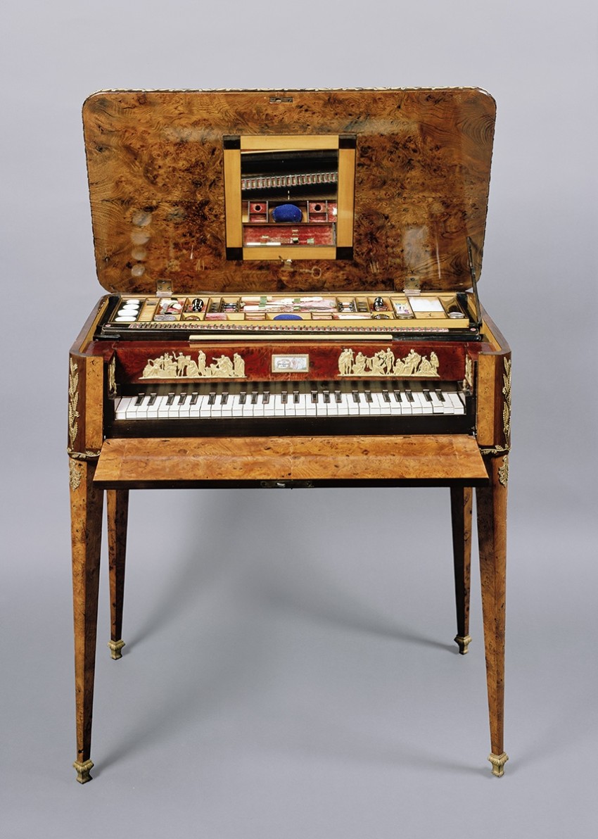Sewing and painting utensiles, spindles and little pots of make-up can be seen in the open table piano.