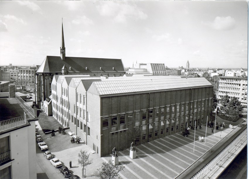 Schwarz/weiß-Foto. Luftaufnahme des Museumsbas und der angrenzende Minoritenkirche von 1957