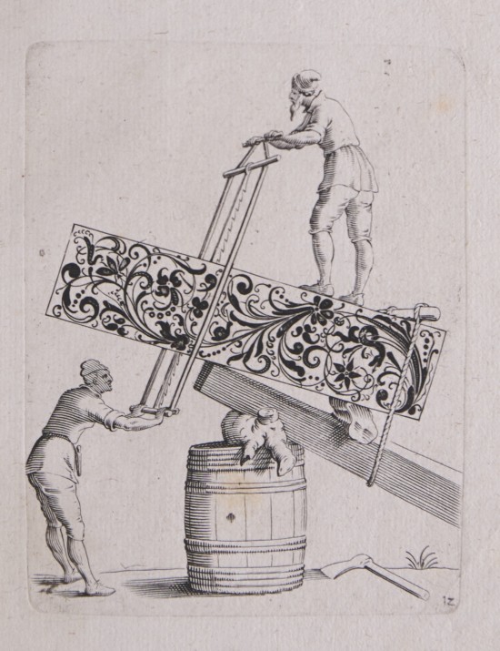 Eine männliche Person steht oben auf einer mit Ornament geschmückten Platte, die auf einem Holzfass ruht und die er gemeinsam mit einem unter ihm stehenden Mann auseinandersägt.UB09877: Goldschmiedevorlage mit Darstellung eines holzverarbeitenden Handwerks