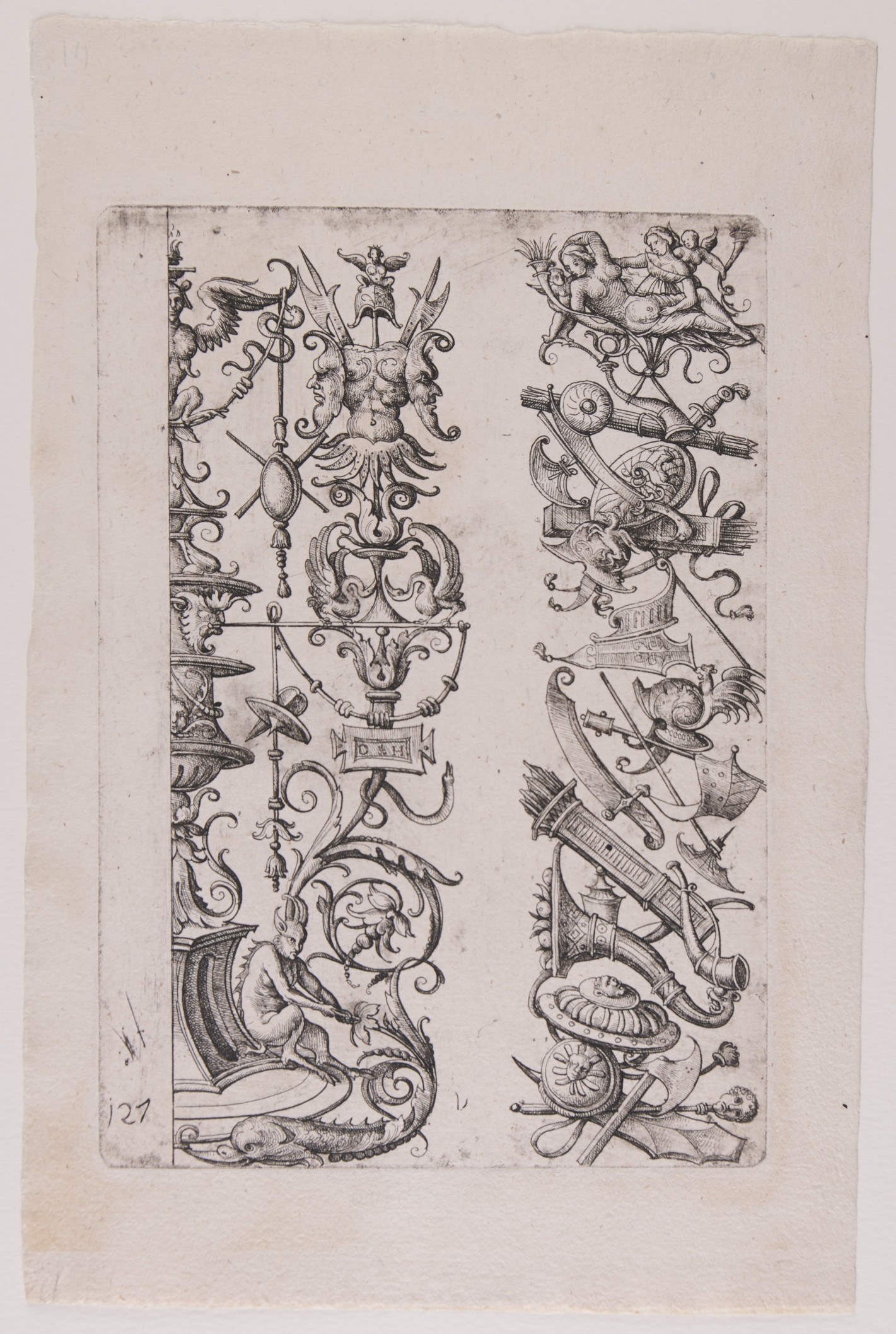 Zwei senkrechte Streifen bestehend aus unterschiedlichen schmückenden Elementen, wie Waffen, Instrumente, Blütenranken und grotesken Figuren.