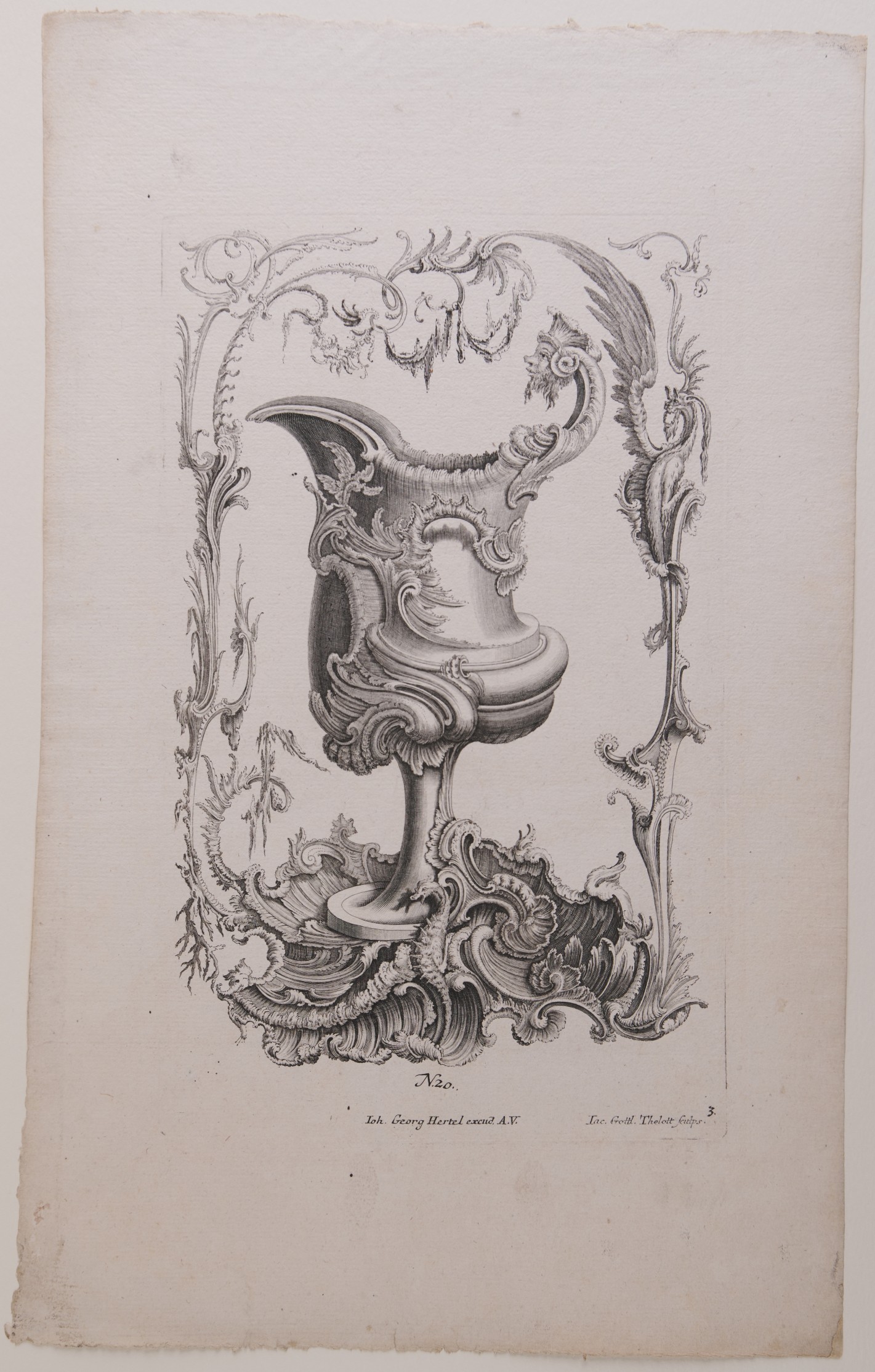 Kelchartiges Gefäß, umgeben von verschlungener Rahmung und verschiedenen Lebewesen.