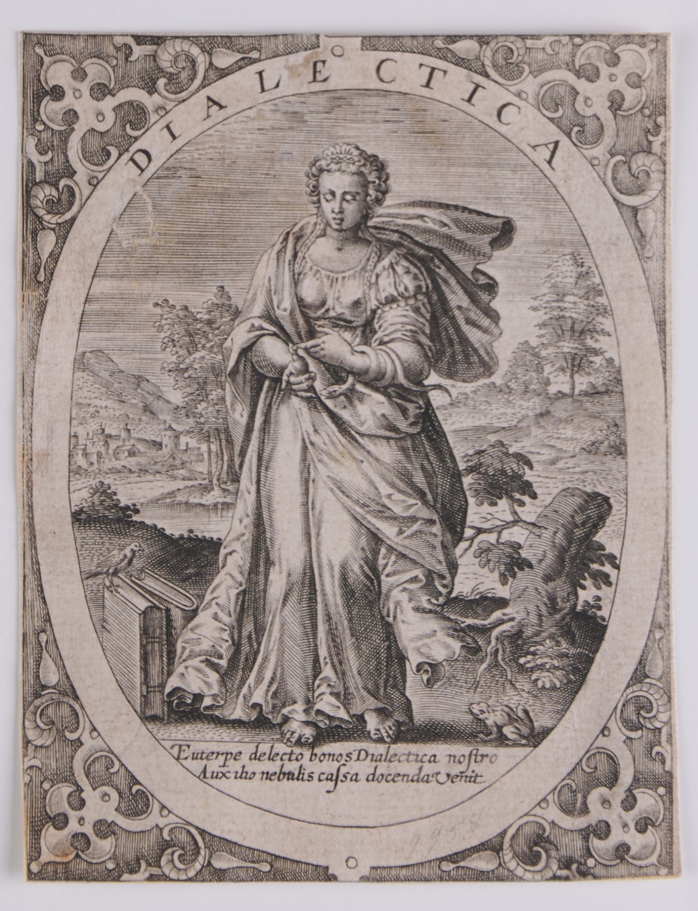 Weibliche Person mit Gewand und zwei langen Zöpfen vor Landschaft. Um ihren linken Arm windet sich eine Schlange, sie weist mit dem linken Zeigefinger auf ihren rechten Daumen. Im Vordergrund am Boden zwei Bücher und ein Frosch.